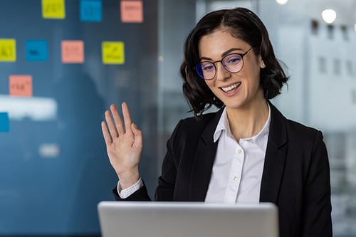businesswoman-waving-during-a-video-call-looking-a-2024-07-01-22-24-17-utc